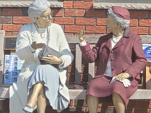 Painting of women sitting on park bench in front of their apartment building. When looking to sell an older home, buyers offering cash for home in Tacony are great ways to sell older homes in need of a lot of repairs.