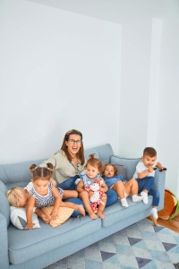 Mother with her 4 children sitting on a couch in their home in Mayfield PA. Joey Loves Philly will buy your house for cash in Mayfield