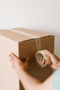 Packing box being sealed with tape. People looking to move quickly will often find a cash for home buyer in Philly to make a sale fast